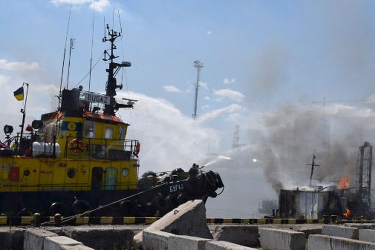 Gambar selebaran yang disediakan oleh saluran Telegram Dewan Kota Odessa pada 24 Juli 2022, menunjukkan petugas pemadam kebakaran Ukraina memerangi api di atas kapal yang terbakar di pelabuhan Odessa setelah rudal menghantam pelabuhan pada 23 Juli 2022. 