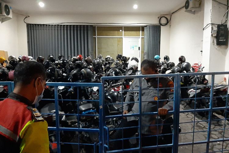 Anggota Polisi saat berjaga di gerbang depan bangunan yang diduga kantor operator pinjaman online di Jalan Prof Herman Yohanes, Caturtunggal, Kapanewon Depok, Kabupaten Sleman