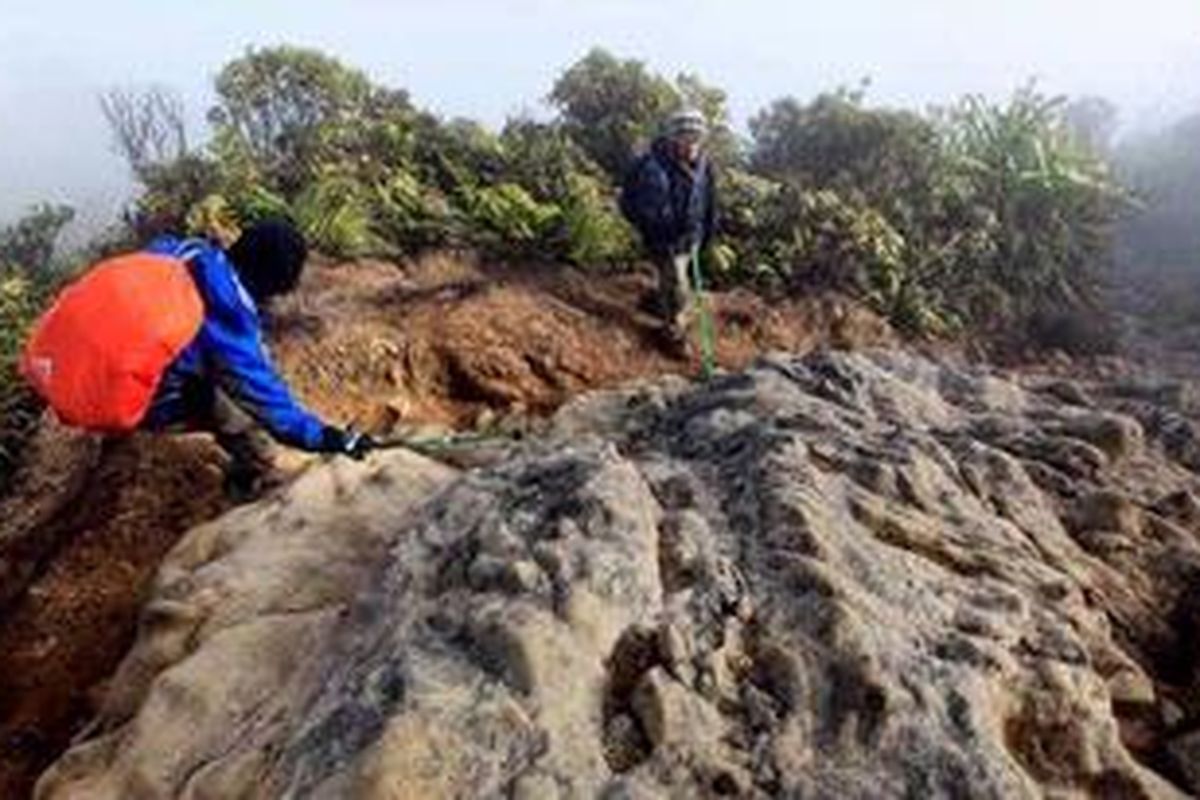 Tim Ekspedisi Cincin Api Kompas menuruni lereng terjal dan cadas meninggalkan puncak Gunung Sinabung (2.460 mdpl), Kabupaten Karo, Sumatera Utara, Rabu (27/7/2011). Gunung ini meletus September 2010 dan memaksa sekitar 12 ribu orang mengungsi. Tim ekspedisi mendaki gunung ini sebagai rangkaian liputan memetakan masalah geografi, sejarah dan masyarakat yang hidup di sekitar kawasan gunung berapi.