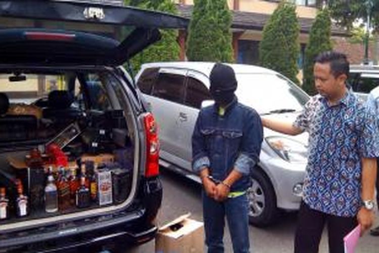 Subagio peracik sekaligus pemilik home industri miras import palsu berserta barang bukti saat berada di Polres sleman