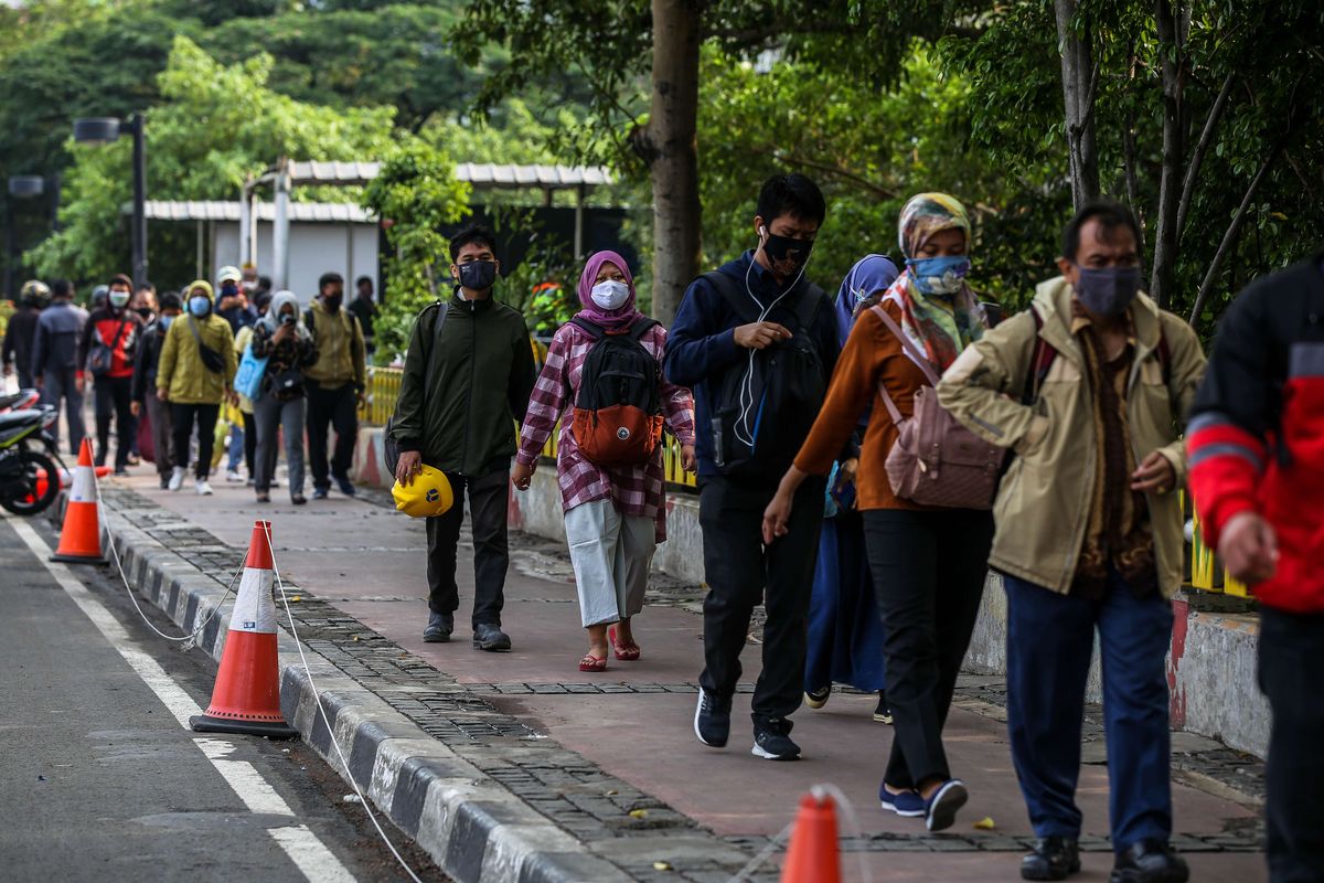 Pekerja yang menggunakan masker saat berjalan menuju kantor masing-masing di Jalan M.H Thamrin, Jakarta Pusat, Senin (14/9/2020). PSBB kembali diterapkan tanggal 14 September 2020, berbagai aktivitas kembali dibatasi yakni aktivitas perkantoran, usaha, transportasi, hingga fasilitas umum.