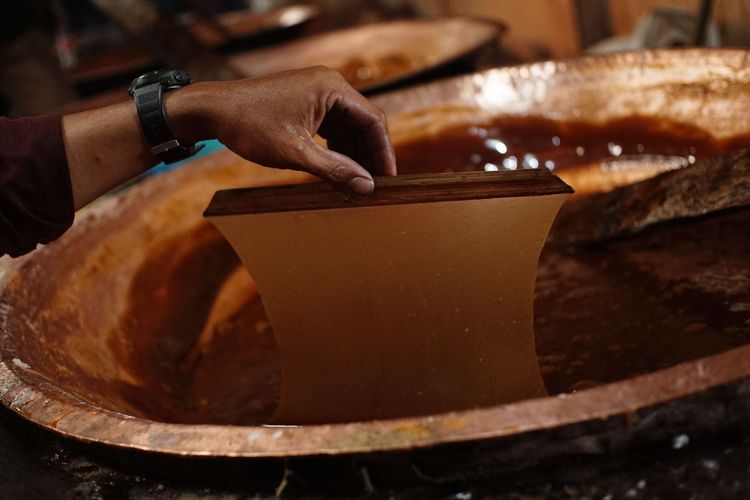 A worker checks the maturity level of dodol dough at the Ny Dodol and Cake production house. Lauw (LKW), in Tangerang, Banten, Friday (17/1/2025).