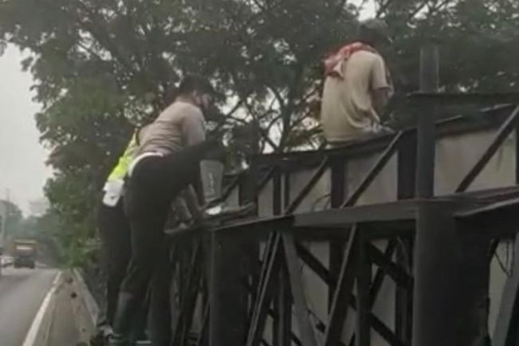 Sugeng dievakuasi polisi karena hendak terjun dari atas papan iklan di Bundaran Satelit Surabaya, Sabtu (16/4/2022) siang