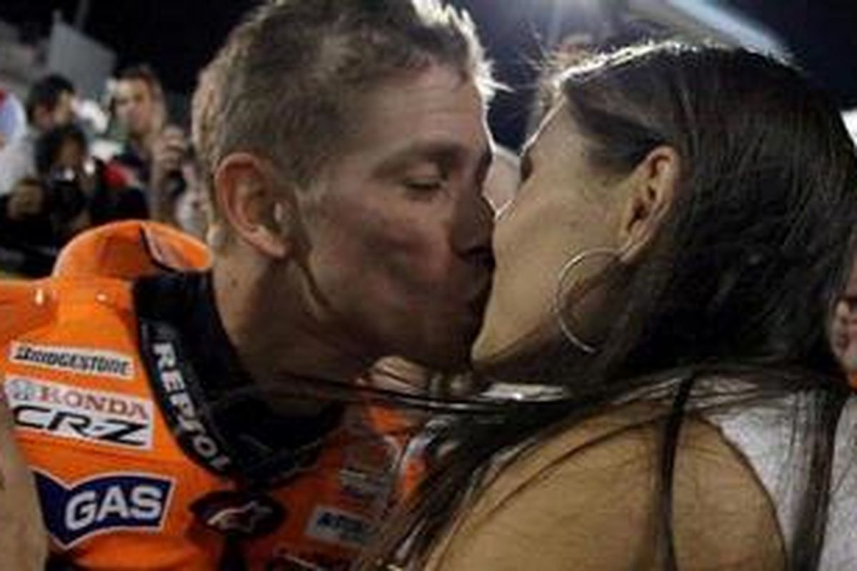 Pebalap Honda, Casey Stoner (kiri), mencium istrinya, Adriana, usai dia memastikan meraih pole position GP Qatar, Sabtu (19/3/11).
