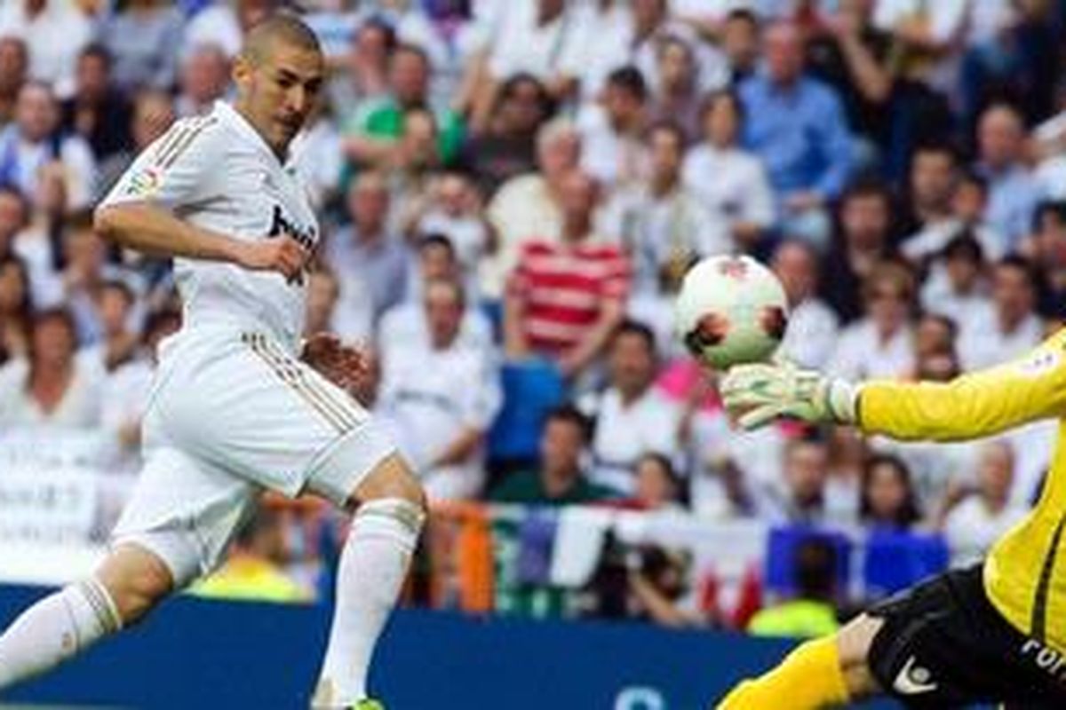 Bomber Real Madrid asal Perancis,  Karim Benzema (kiri), bertarung dengan kiper Mallorca dari Israel, Dudu Aouate, dalam lanjutan Liga BBVA pekan ke-38, Minggu atau Senin (14/5/2012) dinihari WIB.