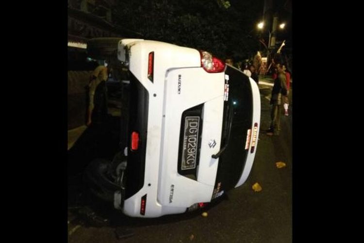 Sebuah mobil Suzuki Ertiga yang membawa 8 mahasiswa terbalik setelah menabrak tiang listrik dan pohon di Kota Ternate, Maluku Utara, Jumat (27/1/2017) 