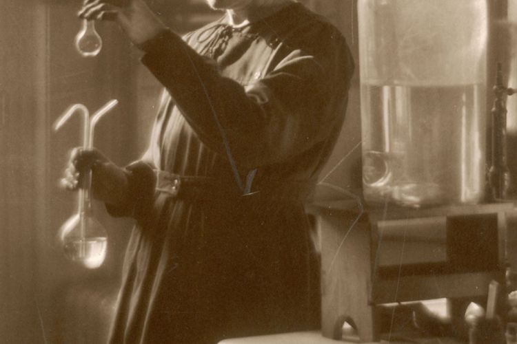 Marie Curie bekerja di laboratoriumnya di Universitas Paris pada 1925. (Historia/REX/Shutterstock.com via Britannica)