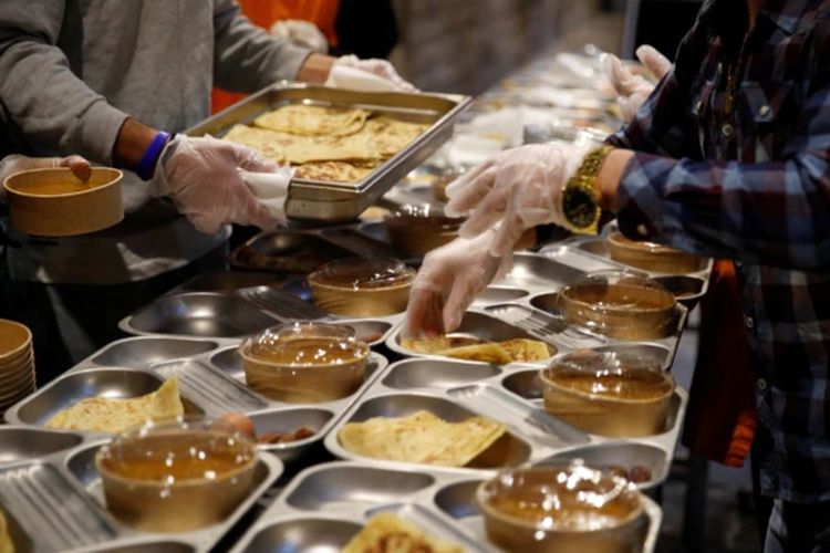 Sukarelawan menyiapkan makanan untuk kegiatan amal berbuka puasa Ramadan di gereja Santa Anna, Barcelona, Spanyol, di tengah pandemi Covid-19, 28 April 2021.