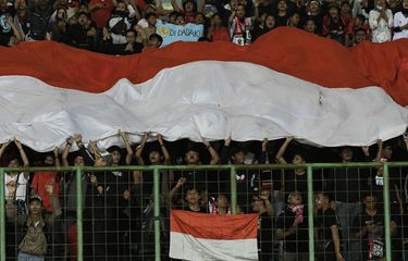 Sejumlah suporter tim sepak bola timnas U19 Indonesia memberikan dukungan dengan membentangkan bendera Merah Putih pada laga lanjutan Grup A Piala AFF U19 2022 melawan Filipina Stadion Patriot Chandrabhaga, Bekasi, Jawa Barat, Jumat (8/7/2022). Indonesia menang dengan skor 5-1. ANTARA FOTO/ Fakhri Hermansyah.