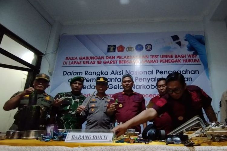 Kepala Lapas Kelas IIB Garut, Rusdedy (keempat kiri) bersama perwakilan dari instansi lainnya menunjukkan barang bukti hasil penggeledahan kamar narapidana di Lapas Kabupaten Garut, Jawa Barat, Kamis (23/11/2023) malam. 