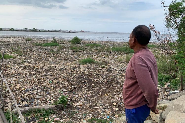 Agus (60), warga di Kampung Nelayan Marunda Kepu, Jakarta Utara, menatap ke arah pesisir yang dipenuhi sampah, Senin (22/1/2024). 