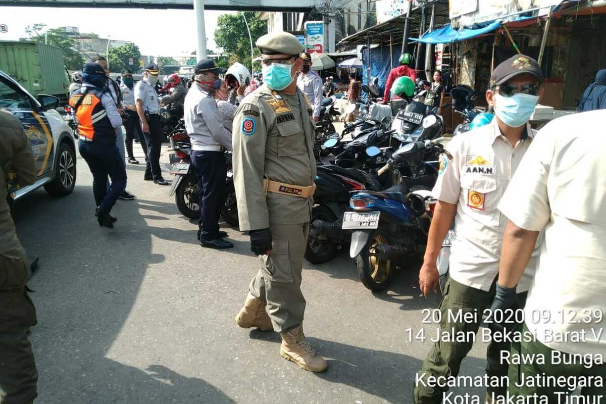 Personel gabungan bersiap menertibkan para pedagang kaki lima di sekitaran Pasar Jatinegara, Jakarta Timur, Rabu (20/5/2020).