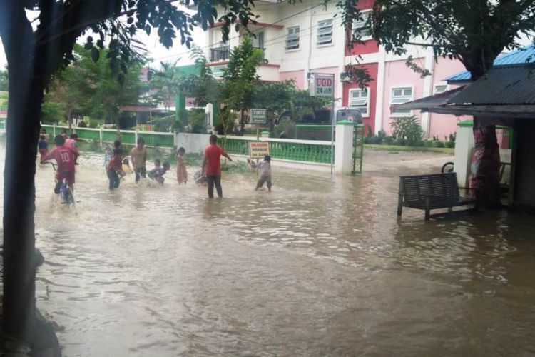 Anak-anak terlihat bermain di jalan yang terendam banjir di depan Puskesmas Matangkuli, Kecamatan Matangkuli, Kabupaten Aceh Utara, Senin (10/1/2018)