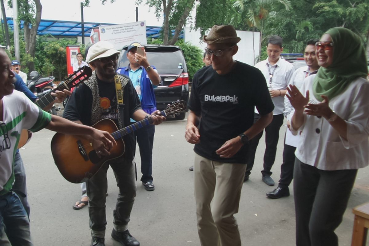 Calon wakil gubernur DKI Jakarta Sandiaga Uno joget bersama musisi jalanan usai makan siang di pujasera Melawai, Jakarta Selatan, Selasa (4/4/2017).