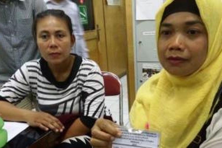 Pujia Wati (jilbab kuning) menunjukkan kartu identitas mahasiwa anaknya, Fahmi Perdana Putra, saat melapor ke Kantor Lembaga Bantuan Hukum (LBH) Medan, di Jalan Hindu, Kamis (20/8/2015). 
