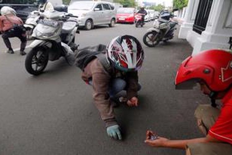 Sejumlah pengendara motor yang peduli memunguti ranjau paku yang disebar di belakang Istana Negara, Jakarta, Kamis (7/2/2013). Menurut mereka, penyebaran ranjau paku di lokasi tersebut sudah terjadi dua pekan ini, pada siang hari menjelang jam pulang kantor.

