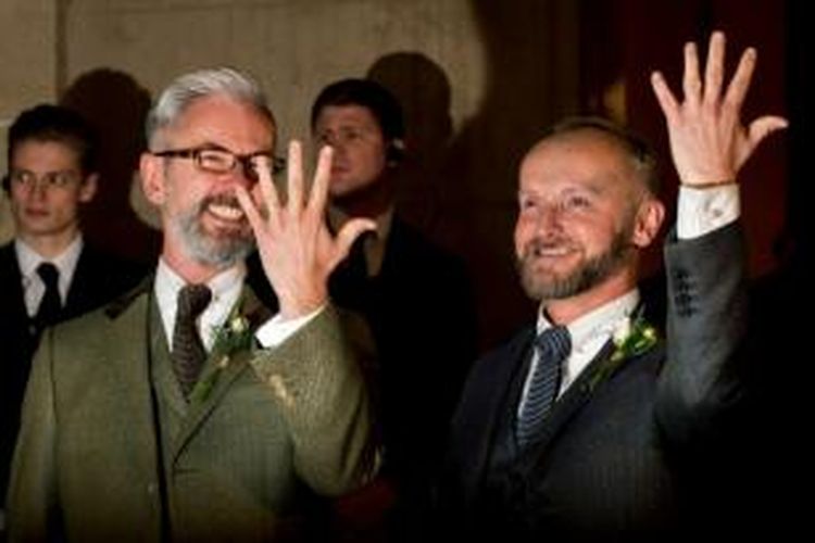 Pasangan gay, Andrew Wale (kiri) and Neil Allard menunjukkan cincin kawin setelah menikah di Royal Pavillion, Brighton, Sabtu (29/3/2014) dini hari setelah hukum di Inggris mengizinkan pernikahan sejenis.