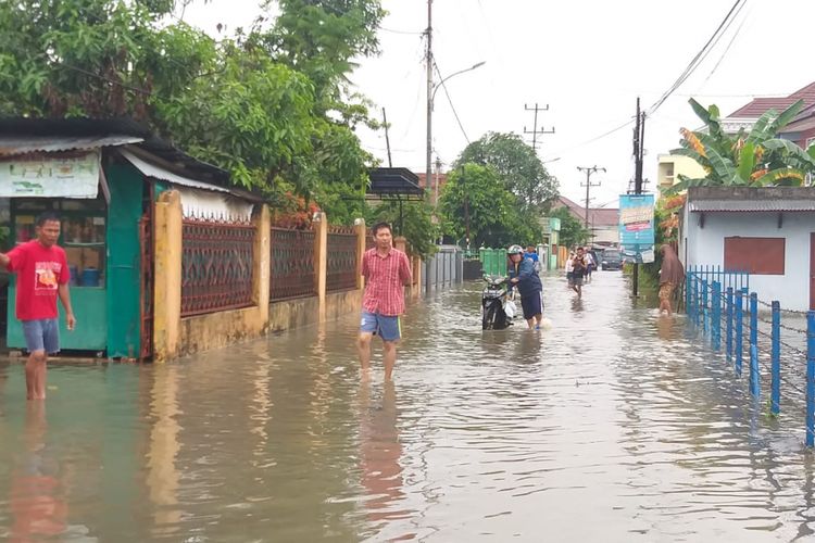 Salah satu motor warga mati mesin ketika melintas di jalan Letnan Simanjuntak Palembang, Sumatera Selatan akibat jalan terendam banjir, Selasa (13/11/2018).