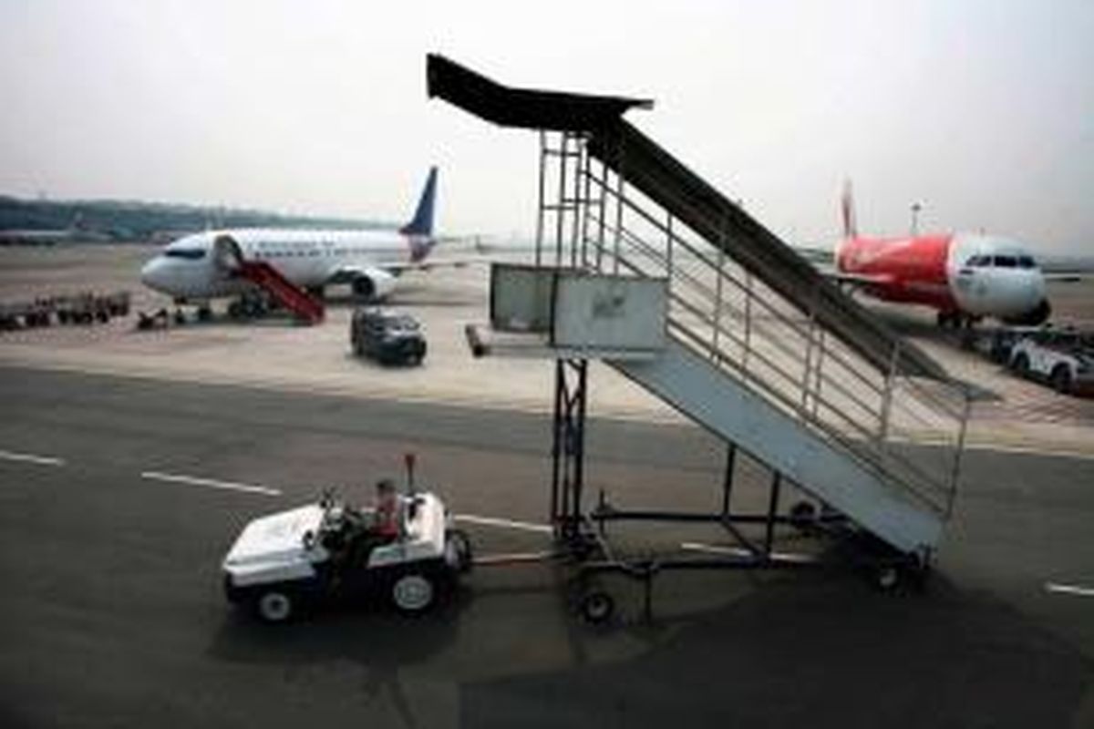 Petugas groundhandlilng JAS Airport Services tengah mempersiapkan keberangkatan pesawat maskapai internasional di hari perdana pengoperasian Bandara Internasional Kualanamu, Deli Serdang, Sumut, Kamis (25/7/2013).