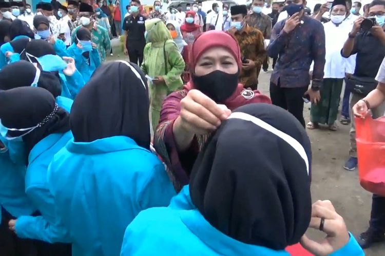 Gubernur Jawa Timur Khofifah Indar Parawansa membantu mengenakan masker kepada salah satu pelajar, pada saat peresmian gedung SMP AL-Hikmah Mlathen Kabupaten Tulungagung Jawa Timur, Rabu (14/04/2021).