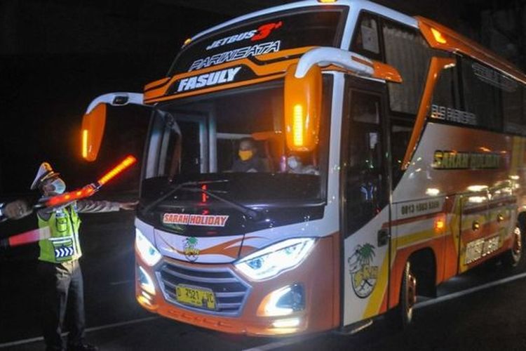 Polisi menghalau bus yang membawa pemudik di tol Jakarta-Cikampek untuk keluar ke Gerbang tol Cikarang Barat, Kabupaten Bekasi, Jawa Barat, Jumat (24/4). Akses transportasi mobil pribadi dan bus angkutan penumpang dari tol Jakarta Cikampek menuju Karawang ditutup mulai Jumat (24/4) pukul 00.00 WIB. 