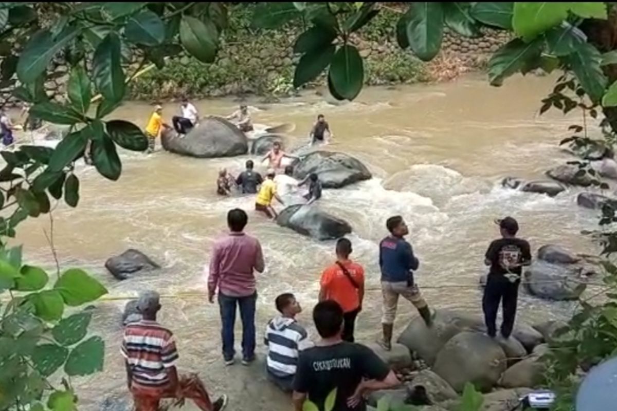 Sejumlah tim gabungan, TNI, Polri, Kecamatan, dan Desa Cikananga, Kecamatan Garawangi, Kabupaten Kuningan, Jawa Barat, berusaha mengevakuasi mayat perempuan di tengah Sungai Cisanggarung, Senin (6/2/2023). Proses evakuasi berlangsung dramatis karena arus deras dan Medan yang terjal.