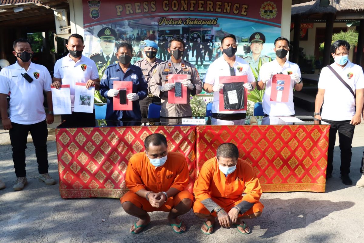 Kedua tersangka duduk jongkok saat rilis pengungkapan kasus penipuan online di Mapolsek Sukawati, Gianyar, Bali, Rabu (27/7/2022). /Dok. Polsek Sukawati