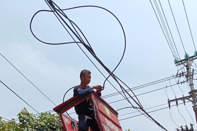 Petugas sedang mengatur kabel menjuntai di Kota Solo, Jawa Tengah