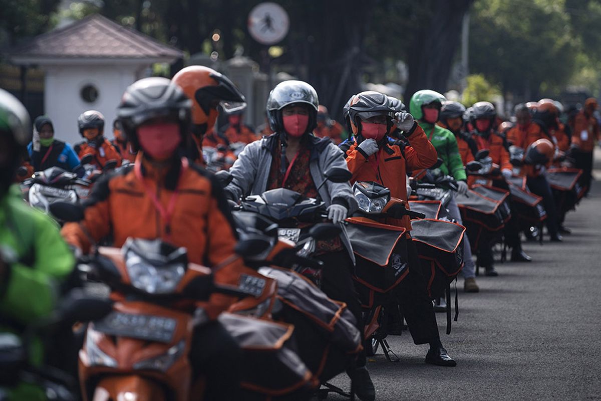 Pegawai PT POS Indonesia (Persero) bersama para ojek daring bersiap mendistribusikan bantuan sosial sembako di depan Istana Merdeka, Jakarta, Senin (20/4/2020). Pemerintah mulai menyalurkan bantuan sosial untuk wilayah di DKI Jakarta dalam rangka penanganan COVID-19 di wilayah Jabodetabek.