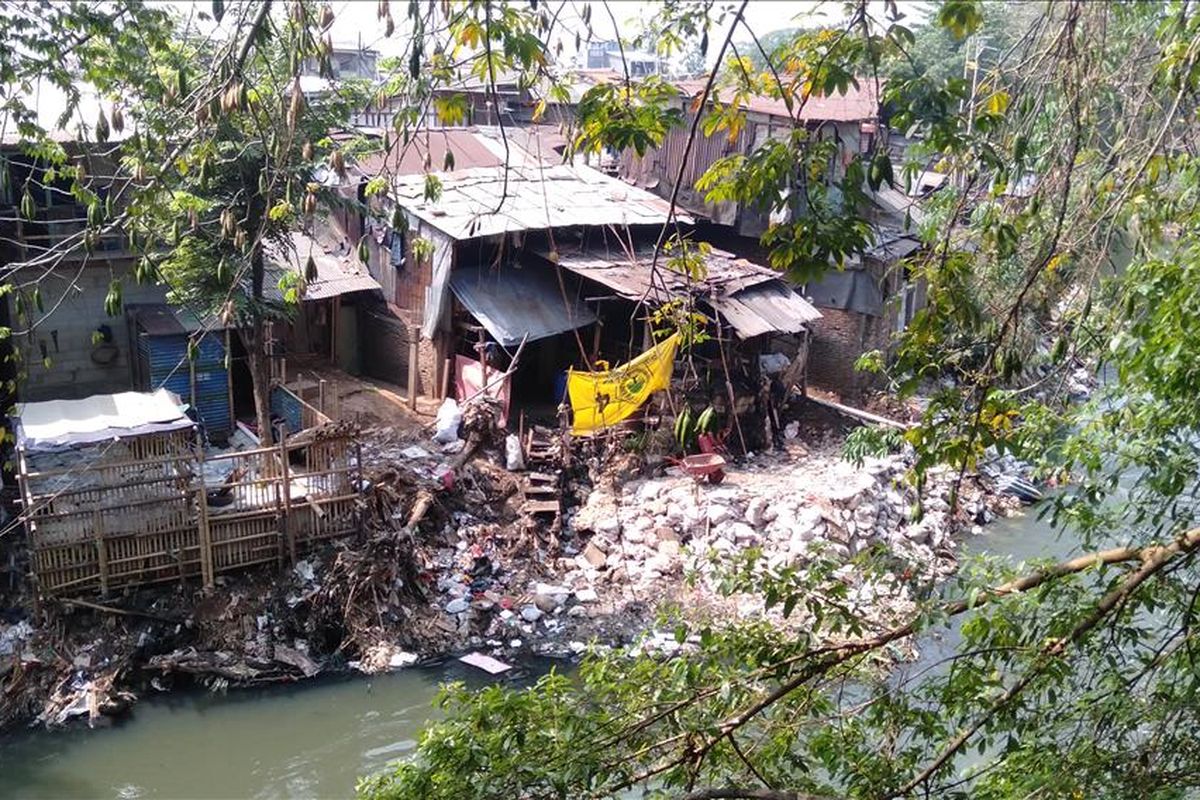 Warga bantaran kali Ciliwung perlebar lahan dengan bebatuan dan tanah yang dimasukan ke dalam karung. Akibatnya kondisi kali menyempit dan aliran air semakin deras, Rabu (14/8/2019)