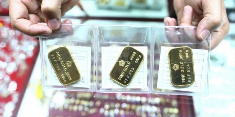 Pedagang emas, memperlihatkan emas batangan Antam seberat 100 gram di kawasan Blok M, Jakarta.