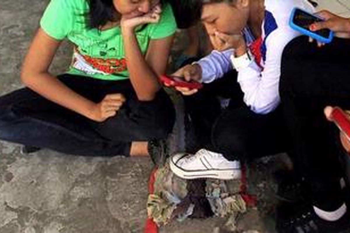 Beberapa remaja tampak asyik menikmati berbagai layanan telepon selulernya di Rumah susun (rusun) Penjaringan, Jakarta Utara, Senin (21/6/2010). Dewasa ini ponsel bukan lagi menjadi sebuah kebutuhan namun telah bergeser menjadi gaya hidup modern. 