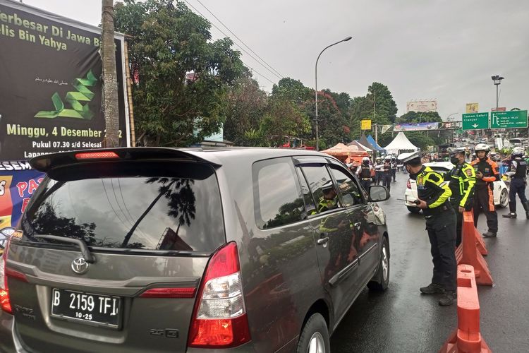 Sejumlah petugas kepolisian melakukan rekayasa lalu lintas di jalur Puncak Bogor, Jawa Barat, Jumat (30/12/2022).