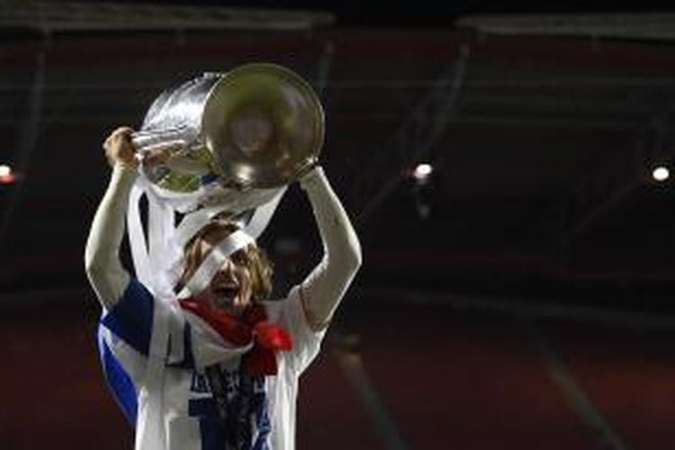 Gelandang Real Madrid, Luka Modric, mengangkat trofi Liga Champions, di Estadio da Luz, Sabtu (24/5/2014).