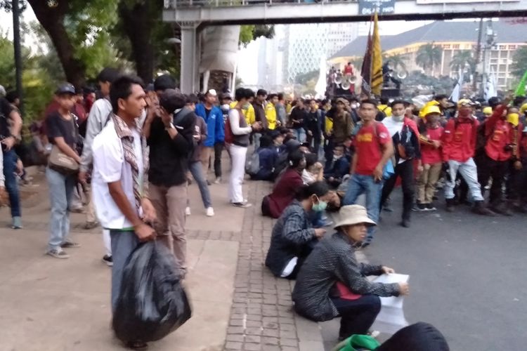 Pelajar punguti sampah saat aksi demonstrasi berlangsung di Jalan Medan Merdeka Barat, Jakarta Pusat, Senin (28/10/2019)