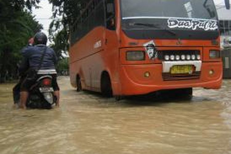 Sebuah bus umum melalui jalan yang tergenang air di Kendal, Jawa Tengah, Selasa (4/2/2014).