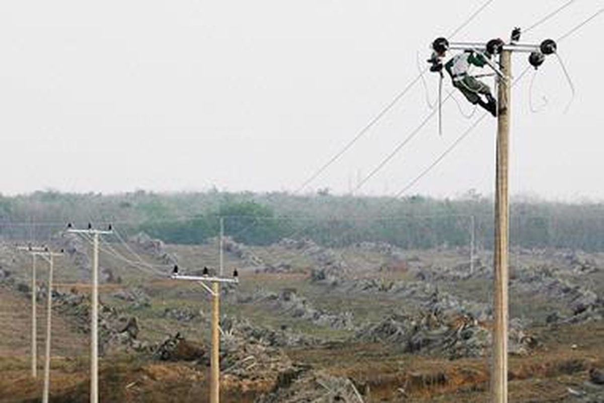 Pekerja memasang instalasi jaringan listrik baru di Kecamatan Betung, Kabupaten Musi Banyuasin, Sumatera Selatan, Kamis (11/8/2011).