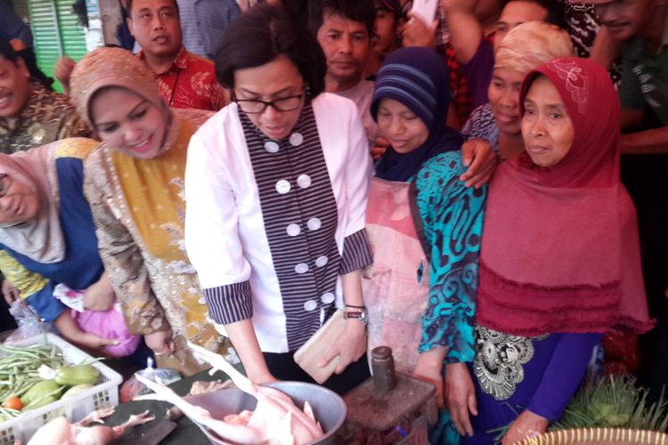 Menteri Keuangan RI Sri Mulyani Indrawati saat menimbang ayam potong di lapak salah satu pedagang di Pasar Besar Kota Malang, Kamis (4/1/2018).