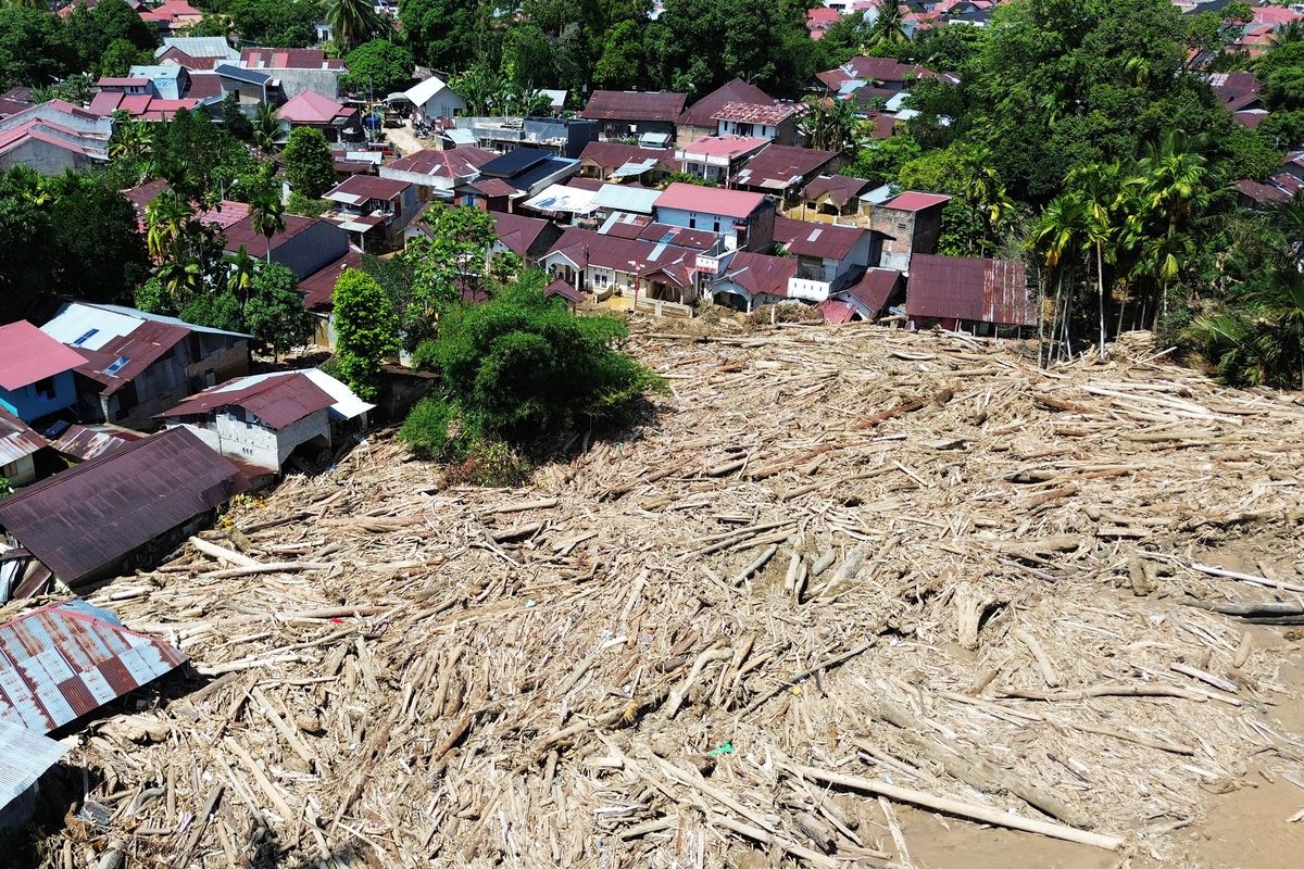 KAYU GELONDONGAN: Foto udara tumpukan gelondongan kayu di permukiman di Tabiang Bandang Gadang, Nanggalo, Padang, Sumatera Barat, Selasa (9/12/2025). Gelondongan kayu yang terbawa banjir bandang sejak dua pekan lalu masih tersangkut di wilayah itu.  