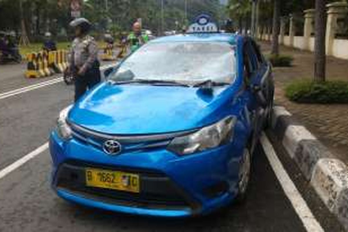 Taksi Sepakat dirusak massa pengojek online di Jalan KH Abdullah Syafii, dekat underpass Jalan Rasuna Said, Selasa (22/3/2016).