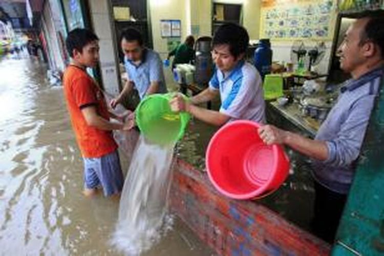 Warga kota Shenzhen, provinsi Guangdong, China mencoba mengeringkan kediaman mereka yang terendam banjir akibat hujan deras dan badai yang menghantam wilayah itu.