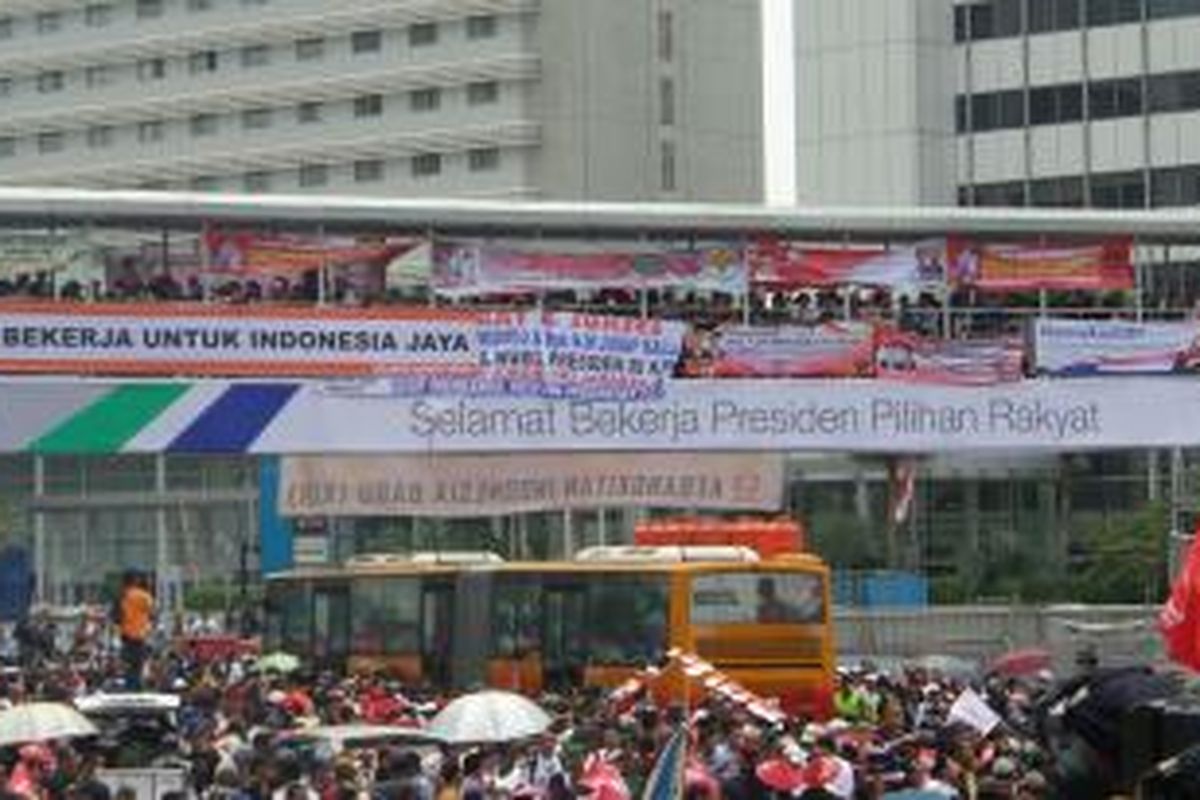 Sebuah bus transjakarta melintas di kawasan Bundara Hotel Indonesia yang sudah dipenuhi massa, Senin 920/10/2014).