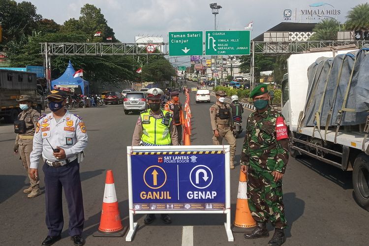 Petugas gabungan sedang menjaga pos pemeriksaan ganjil genap di Simpang Gadog, Kecamatan Ciawi, Kabupaten Bogor, Jawa Barat. Rekayasa lalu lintas berupa sistem ganjil genap kembali diterapkan di Jalur Puncak Bogor, Jawa Barat, Jumat (22/7/2022) pukul 16.00 WIB.