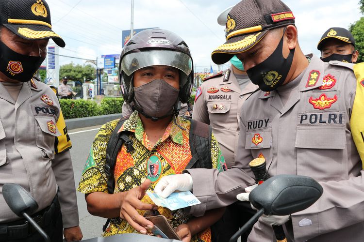 Kapolres Kebumen AKBP Rudy Cahya Kurniawan memberikan hadiah uang kepada pengendara yang patuh menggunakan masker saat operasi yustisi di sekitar Alun-alun Kebumen, Jawa Tengah, Rabu (30/9/2020).