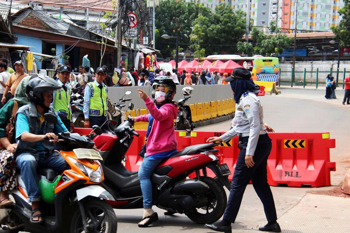 Petugas mengatur jalan yang ditutup di Jalan Jatibaru, Tanah Abang, Jakarta, Jumat (22/12/2017). Sehubung keputusan Gubernur DKI Jakarta Anies Baswedan, ruas jalan di depan stasiun ditutup untuk kendaraan bermotor pada pukul 08.00-18.00 WIB.