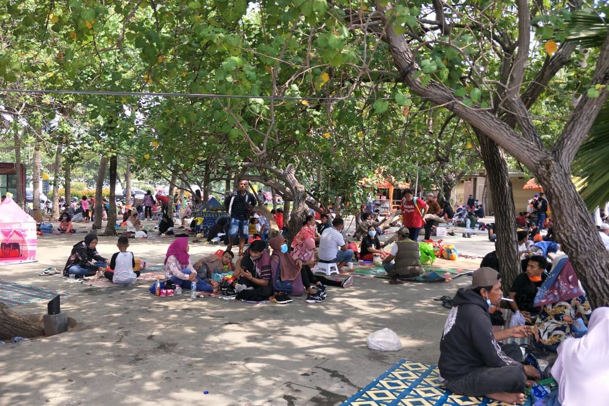 Kawasan wisata Taman Impian Jaya Ancol, tepatnya di Pantai Timur, ramai dikunjungi wisatawan pada hari pertama Idul Fitri, Kamis (13/5/2021).