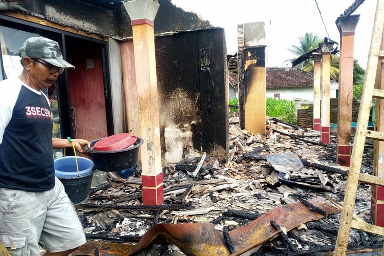 Mukani alias Kentang memindahkan perabotan yang tersisa dari rumahnya yang terbakar, Rabu (1/12/2021)
