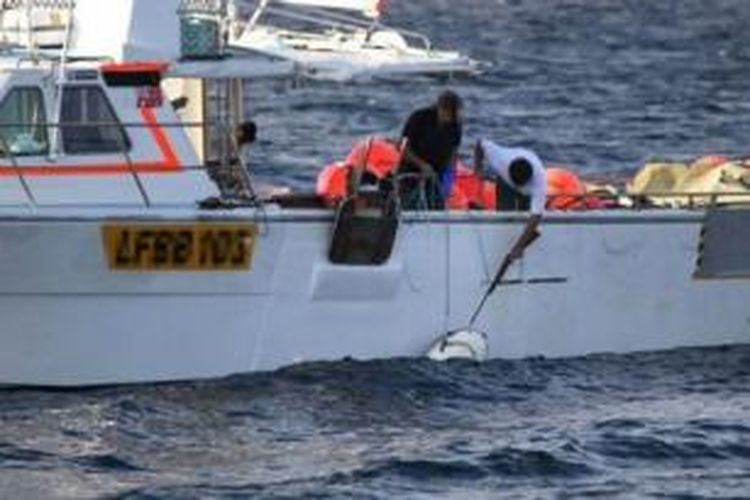 Beginilah cara menembak hiu, Seorang nelayan memegang tali yang menjerat seekor hiu, sementara nelayan lain menembak kepala hewan tersebut. Pemerintah Australia Barat mengizinkan penembakan ikan hiu karena dianggap membahayakan manusia.