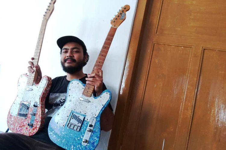 Naufal Fajar Gumelar, 26 tahun, pemuda asal Cianjur, Jawa Barat, memerlihatkan dua gitar elektrik yang dibuatnya dari limbah tutup botol plastik.