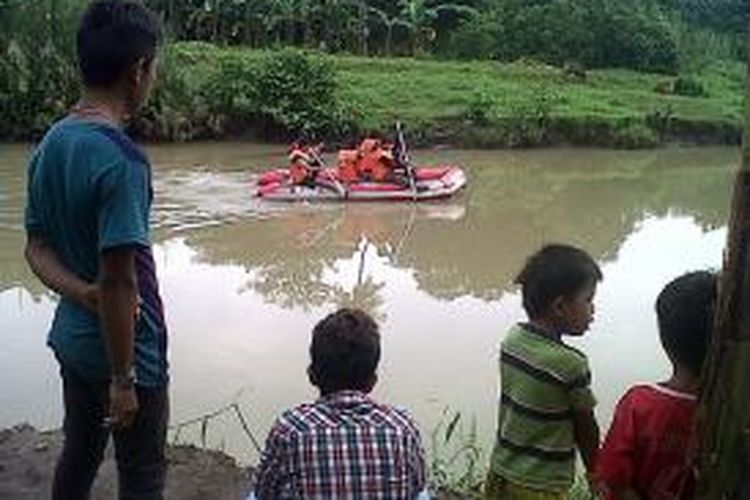 Sejumlah warga di Kabupaten Gowa, Sulawesi Selatan menyaksikan tim Searc And Rescue (SAR) melakukan penyisiran disepanjang sungai untuk mencari jasad Muh. Syawal yang diketahui terpeleset dan tenggelam terseret arus sungai. Senin, (12/01/2015).